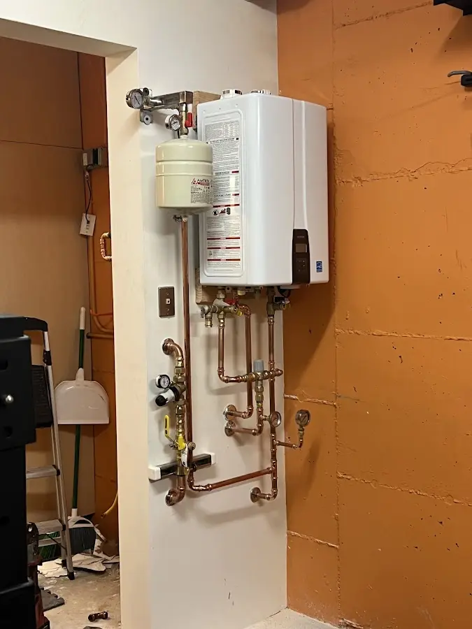 Plumbing technician inspecting water heater connections in Campbellsville